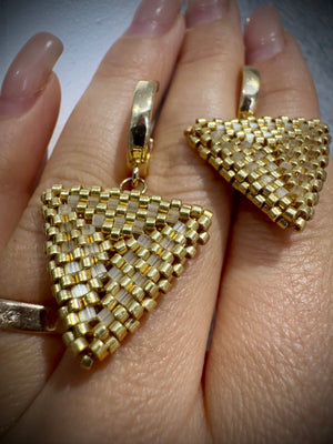 Close up of handwoven gold and blush beaded triangle earrings